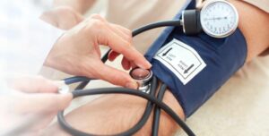 Toma de presión arterial durante una evaluación cardiológica para detectar hipertensión.