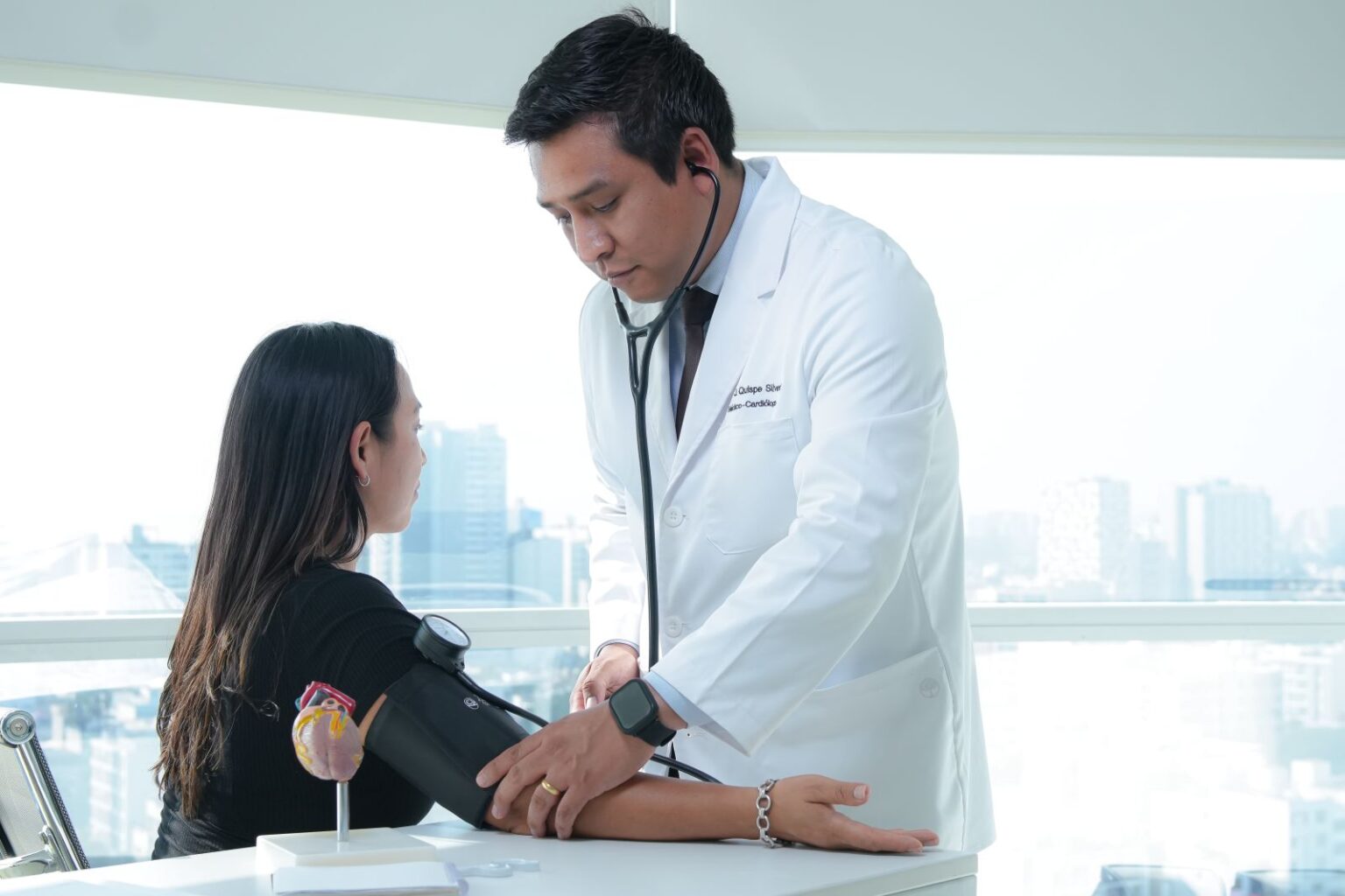 Dr. Edgar Quispe realizando la toma de presión arterial durante una evaluación cardiológica.